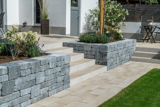 Tocano Blockstufe Umbriano Granitbeige gemasert in Kombination mit Spring Modo Mauer Grau.