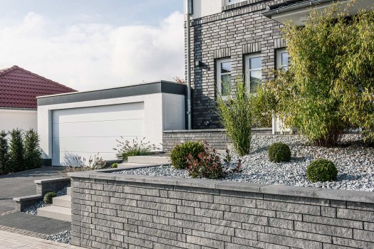 Linaro Mauer Anthrazit-grau gemasert in Kombination mit Tocano-Blockstufen Granithell.